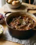 Hollands stoofvlees in een gietijzeren braadpan met aardappelpuree en rode kool